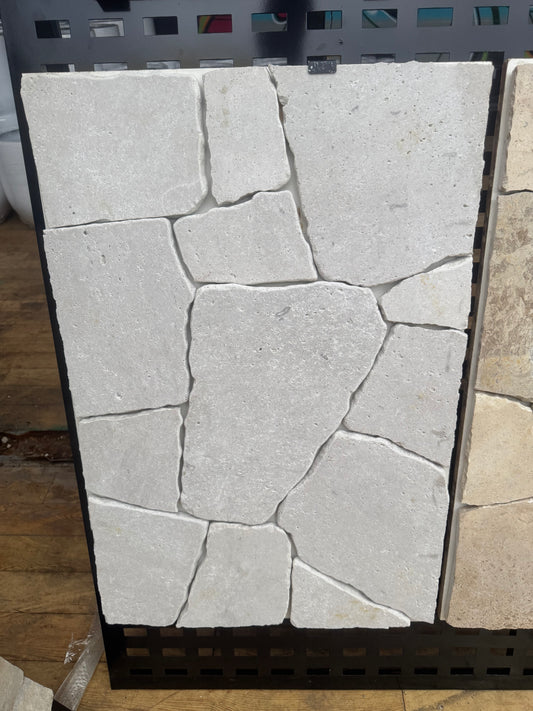 White travertine crazy paving stone from The Nurso, showing irregular, textured outdoor paving with natural stone appearance.