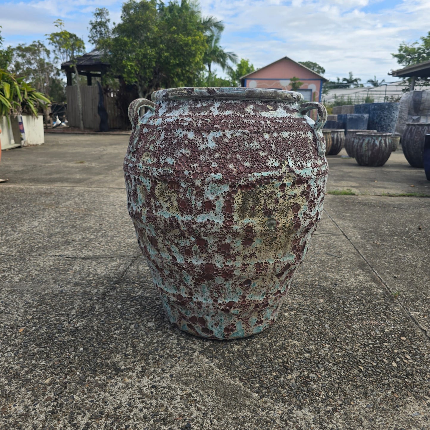 Atlantis jar pot in green and brown, with a rounded shape and decorative design, suitable for indoor or outdoor use.