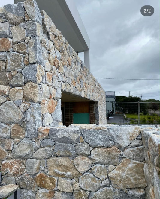 Yellow pearl stone cladding by The Nurso, showing textured natural stone surface with a warm, yellow pearl finish.
