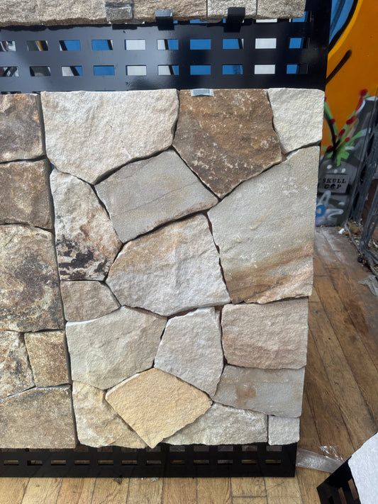 Rustic sandstone sample from The Nurso showing natural textured surface with warm earthy tones.
