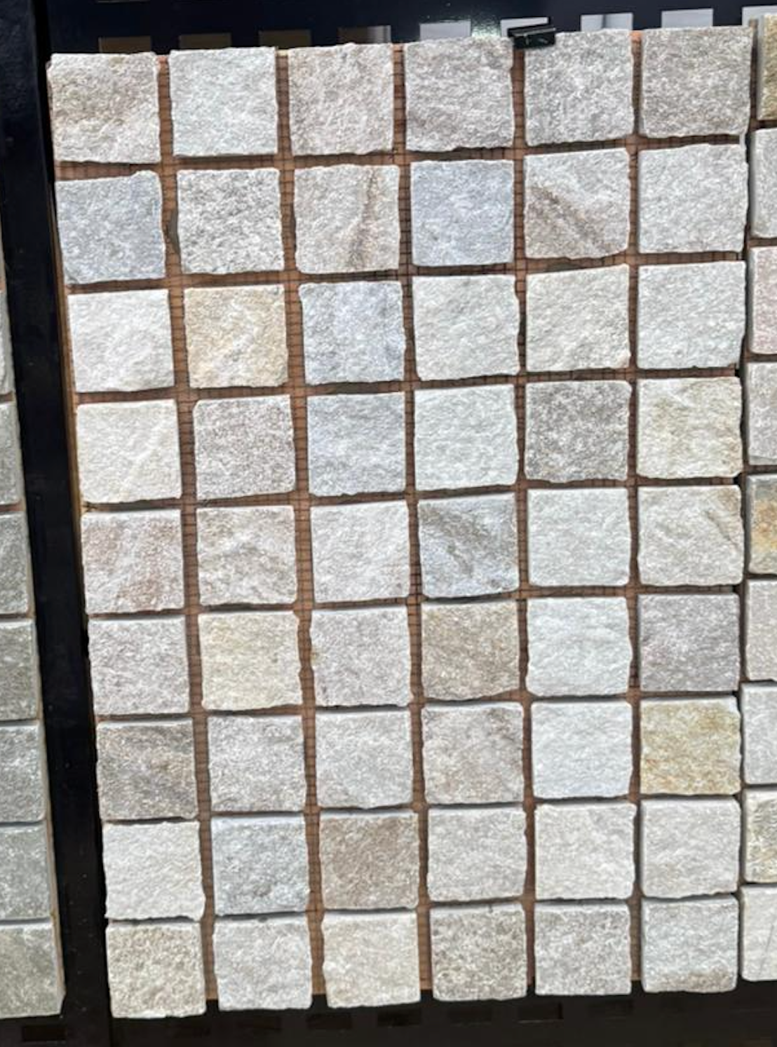 Golden Quartz cobble stone with split face and chipped edge, natural stone paving from The Nurso, showing textured surface and warm golden tones.