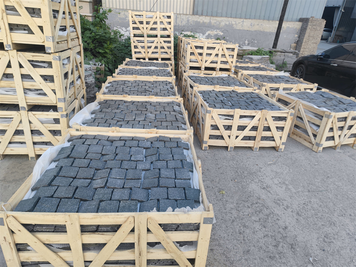 Black granite cobble stone from The Nurso, showing textured, polished surface ideal for landscaping and paving projects.