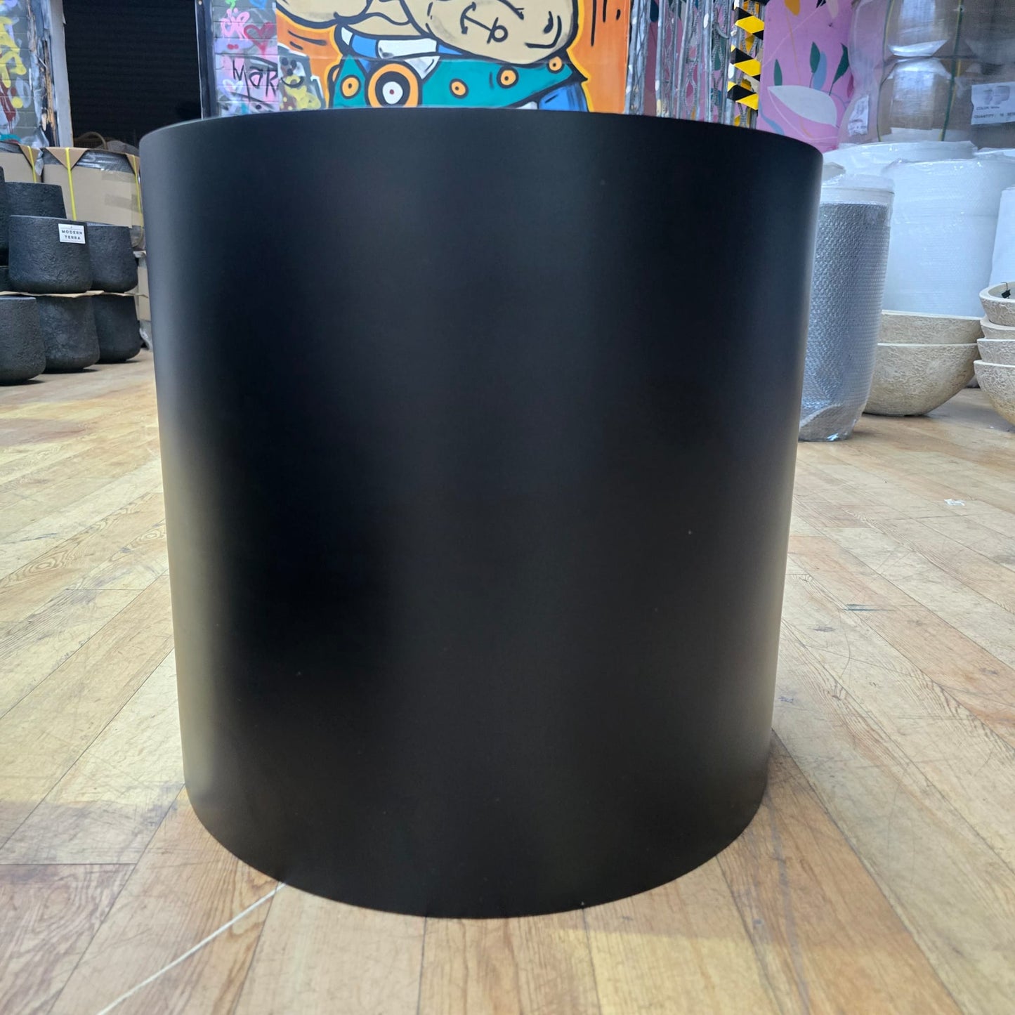 Black cedar cylinder pot, 23cm tall and wide, featuring a sleek, modern design suitable for indoor or outdoor plants.