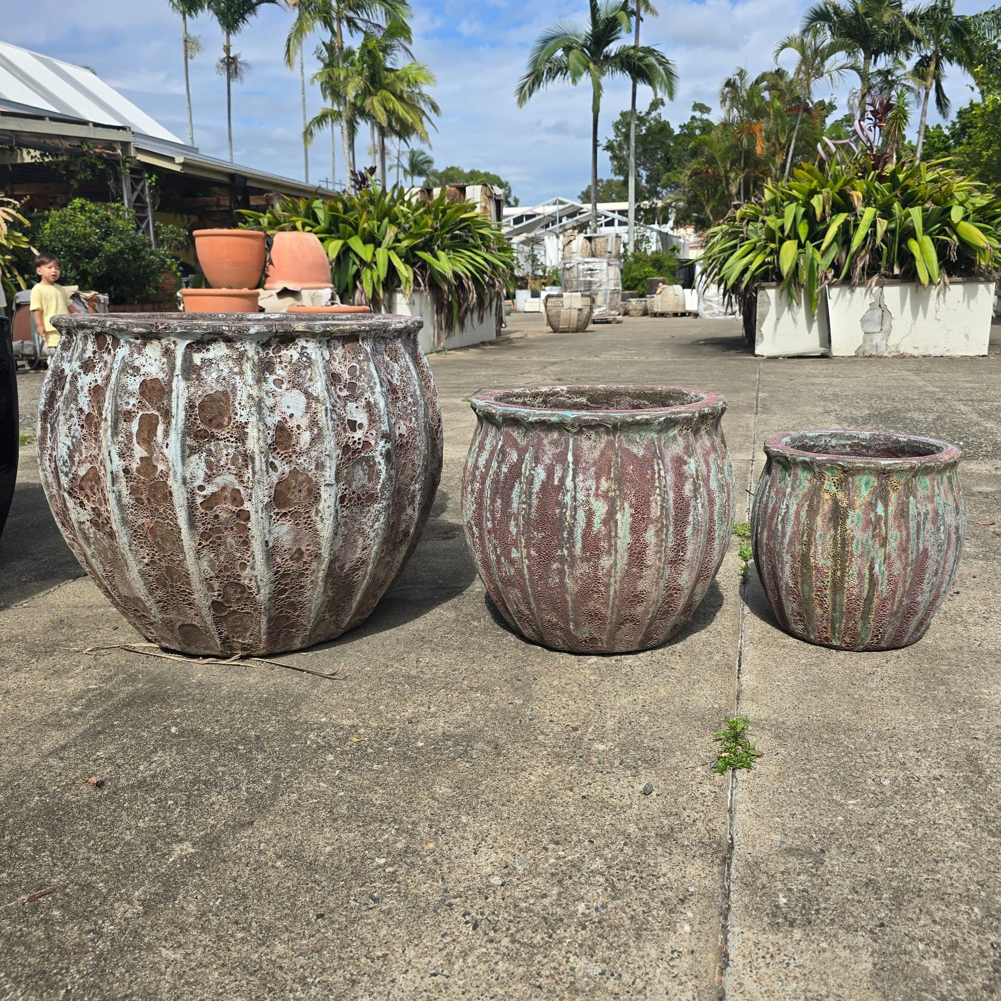 Green and brown vertical ribbed Atlantis pot with a tall, rectangular shape, featuring textured surface and modern design.